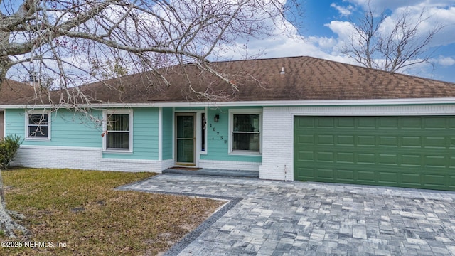 ranch-style house with a garage and a front lawn