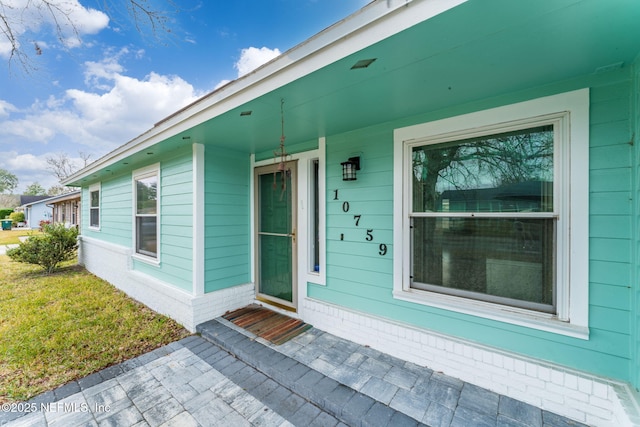 entrance to property with a lawn