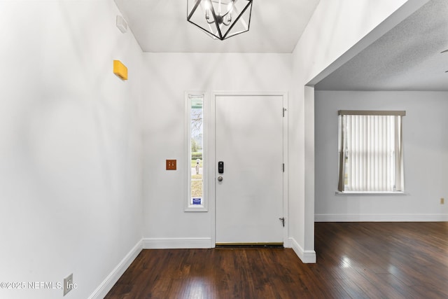 entrance foyer featuring a chandelier and dark wood-type flooring