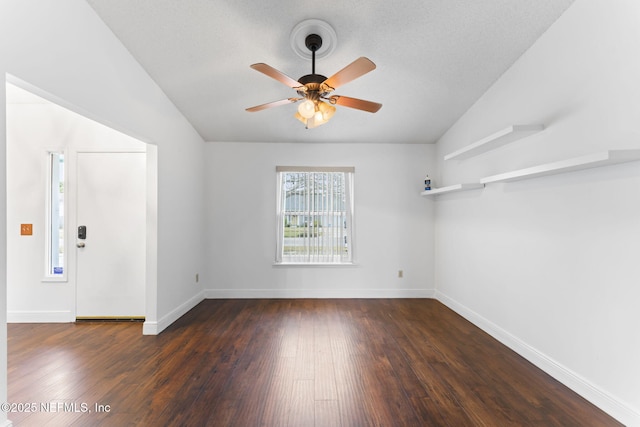 empty room with ceiling fan, dark wood-type flooring, a textured ceiling, and lofted ceiling