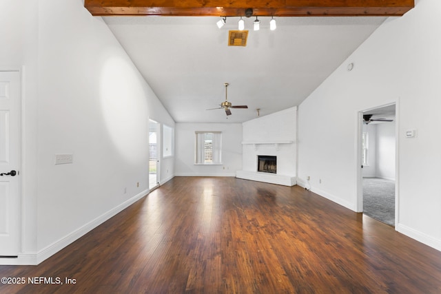 unfurnished living room featuring ceiling fan, dark hardwood / wood-style floors, vaulted ceiling with beams, and a brick fireplace