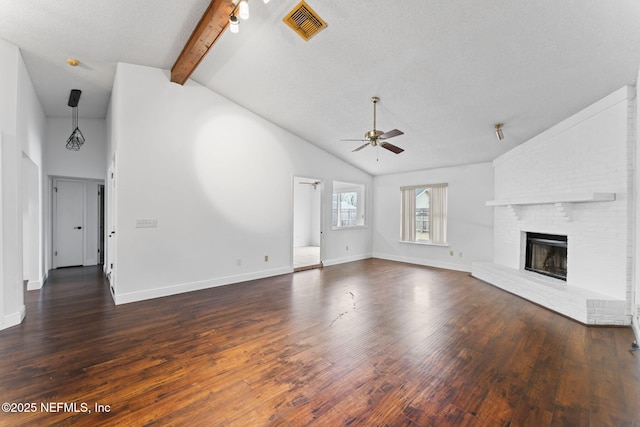 unfurnished living room with a textured ceiling, a brick fireplace, vaulted ceiling with beams, ceiling fan, and dark hardwood / wood-style floors