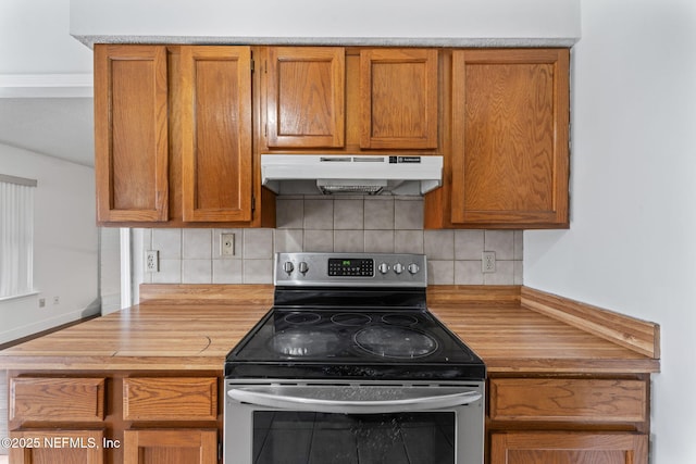 kitchen featuring tasteful backsplash, wood counters, and stainless steel range with electric cooktop