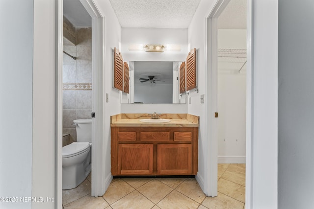 bathroom with vanity, toilet, a textured ceiling, and tile patterned flooring