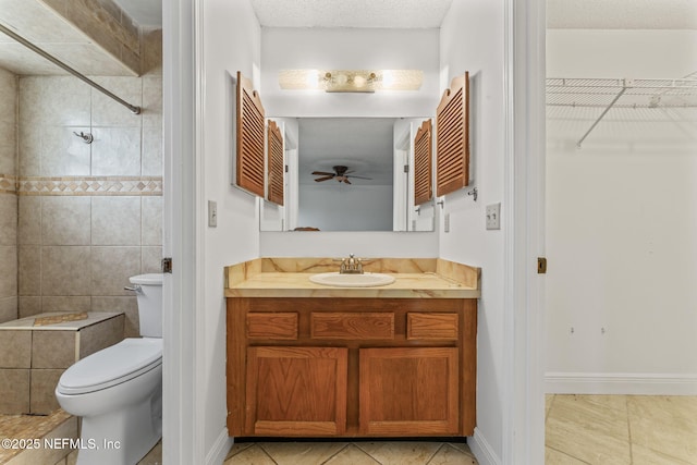 bathroom with tile patterned flooring, ceiling fan, a textured ceiling, toilet, and vanity