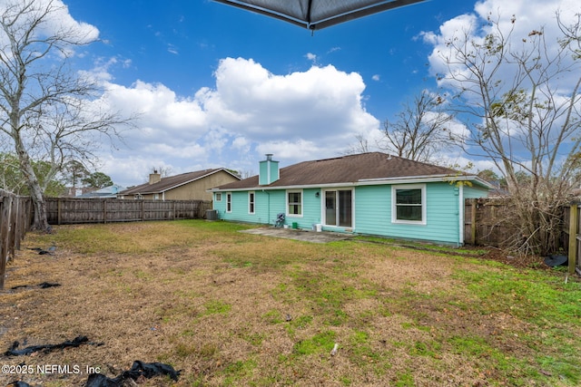 rear view of property featuring a lawn and a patio