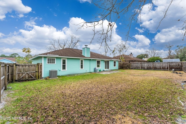 rear view of property featuring central air condition unit and a lawn