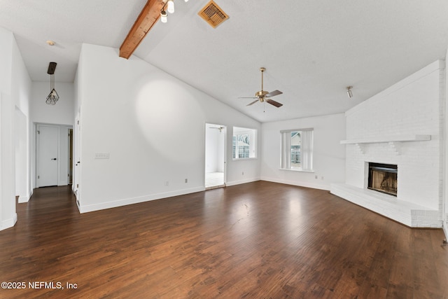 unfurnished living room featuring ceiling fan, dark hardwood / wood-style flooring, lofted ceiling with beams, a fireplace, and a textured ceiling