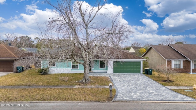 single story home featuring a garage and a front lawn