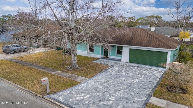 view of front of house featuring a garage and a front lawn