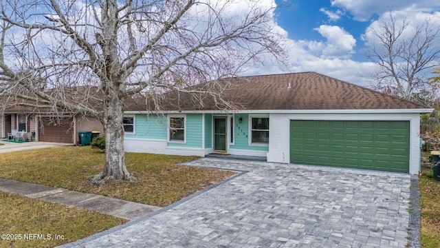 single story home featuring a garage and a front yard