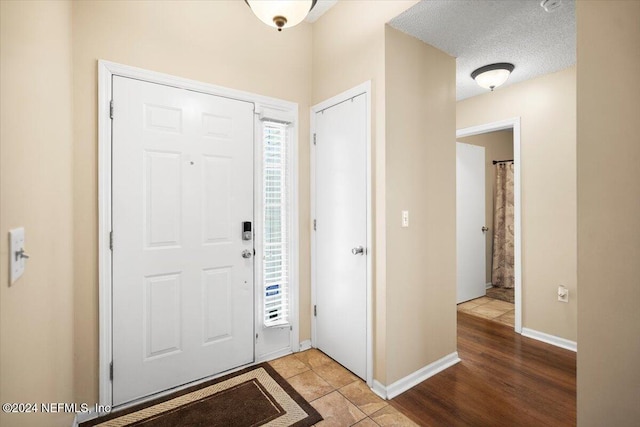 foyer with light tile patterned flooring and a textured ceiling