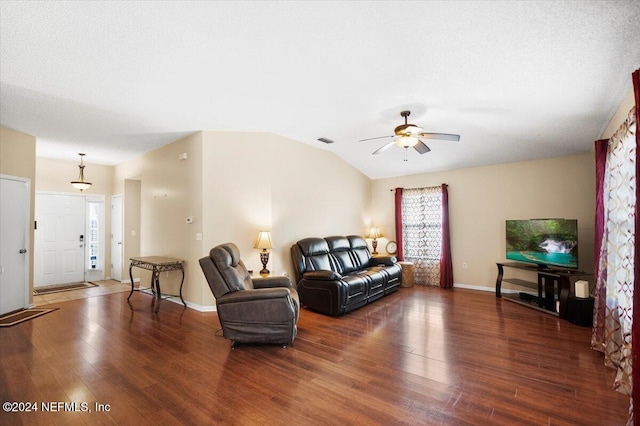 living room featuring dark wood-type flooring, ceiling fan, lofted ceiling, and a textured ceiling