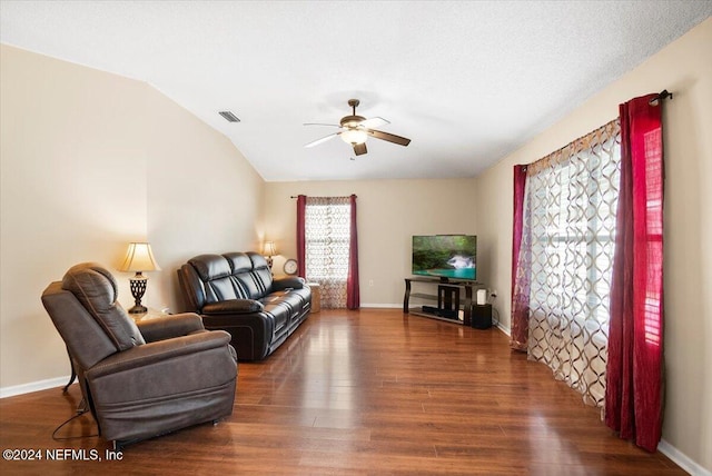 living room with ceiling fan, dark hardwood / wood-style floors, and vaulted ceiling