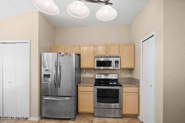 kitchen featuring hanging light fixtures, appliances with stainless steel finishes, a textured ceiling, and light brown cabinetry