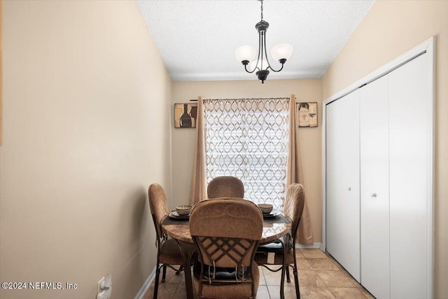 dining area with light tile patterned flooring, a chandelier, and a textured ceiling