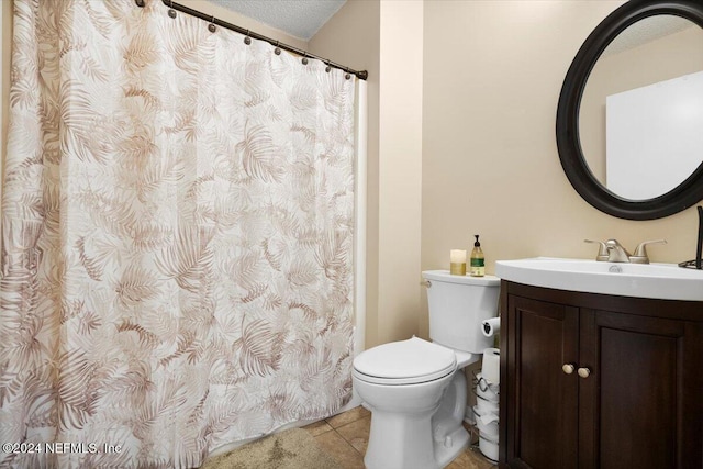 bathroom with tile patterned flooring, vanity, a textured ceiling, and toilet