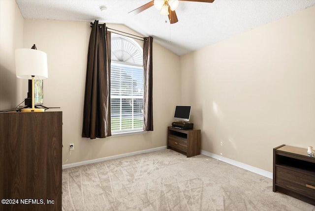 bedroom featuring vaulted ceiling, light colored carpet, ceiling fan, and a textured ceiling