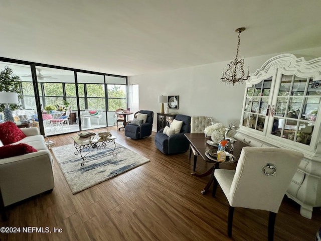 living room featuring ceiling fan with notable chandelier and hardwood / wood-style flooring