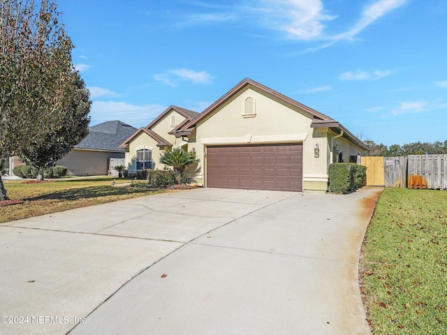 ranch-style house with a garage and a front yard