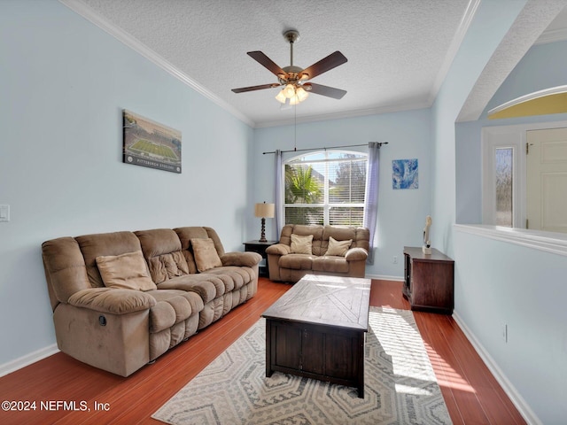 living room with a textured ceiling, light hardwood / wood-style floors, ceiling fan, and ornamental molding