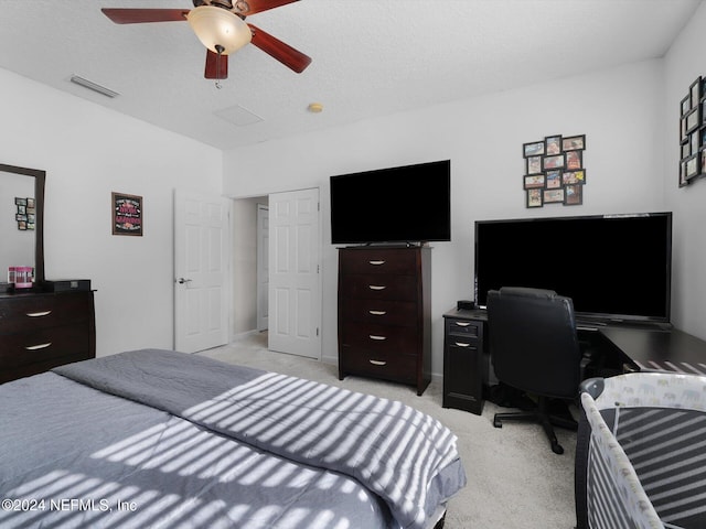 carpeted bedroom with a textured ceiling and ceiling fan