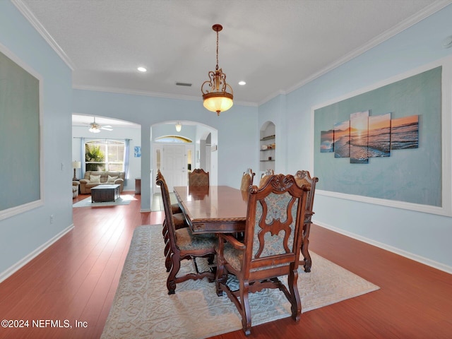 dining room featuring hardwood / wood-style floors, ceiling fan, ornamental molding, and built in shelves