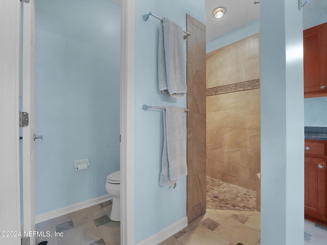 bathroom featuring tiled shower and toilet