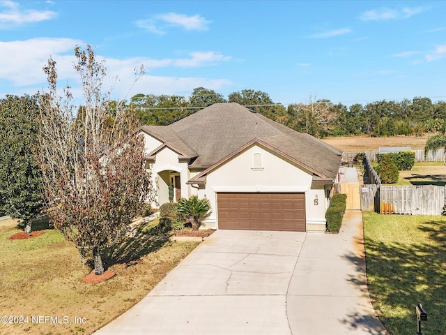 view of front of property featuring a front yard and a garage