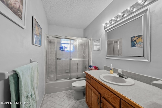 full bathroom featuring tile patterned flooring, enclosed tub / shower combo, a textured ceiling, toilet, and vanity