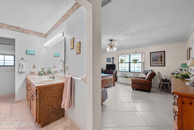 bathroom with vanity, a textured ceiling, ornamental molding, and tile patterned flooring