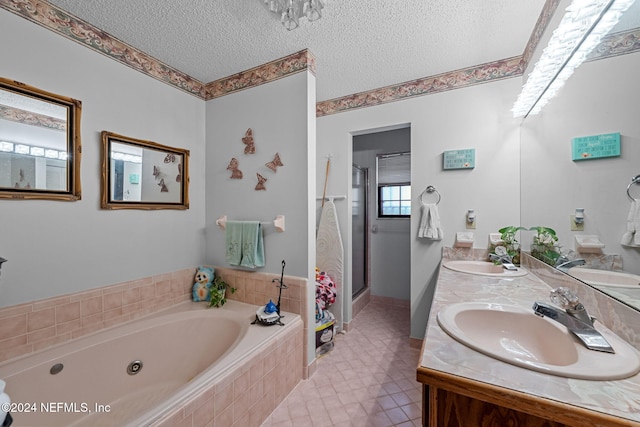 bathroom featuring plus walk in shower, vanity, and a textured ceiling