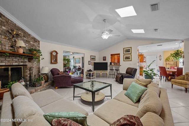 living room featuring ceiling fan, vaulted ceiling with skylight, light tile patterned flooring, and ornamental molding