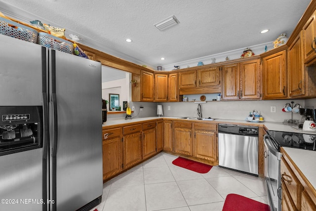 kitchen with sink, light tile patterned floors, a textured ceiling, ornamental molding, and stainless steel appliances