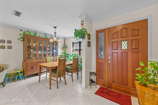 entrance foyer with a chandelier, light tile patterned floors, and ornamental molding