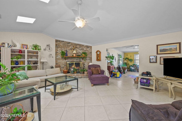 living room featuring crown molding, vaulted ceiling with skylight, light tile patterned floors, and ceiling fan