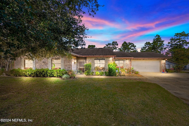 view of front of house with a garage and a lawn