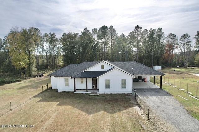 modern inspired farmhouse featuring a front lawn and a carport