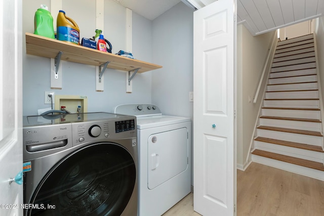 clothes washing area featuring independent washer and dryer and light hardwood / wood-style flooring