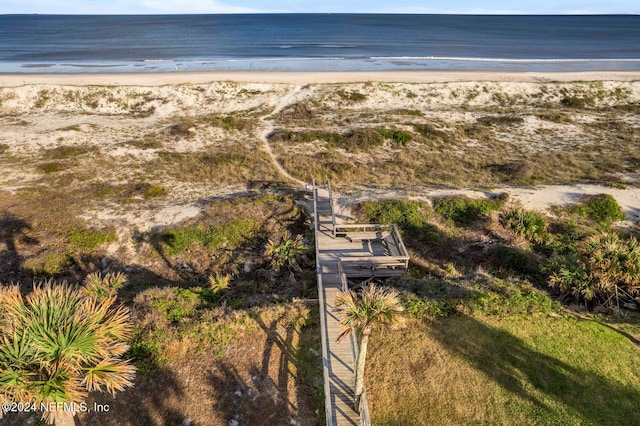 drone / aerial view with a water view and a beach view