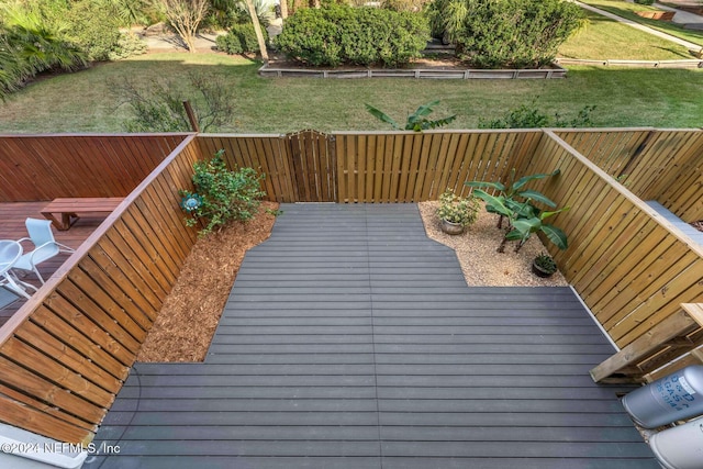 wooden terrace featuring a lawn