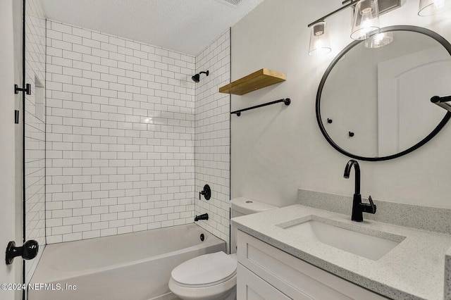 full bathroom featuring tiled shower / bath, vanity, toilet, and a textured ceiling