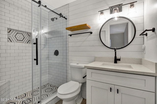 bathroom featuring vanity, toilet, and a shower with shower door