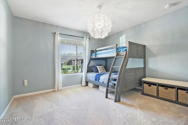 bedroom featuring a chandelier, a textured ceiling, and carpet floors