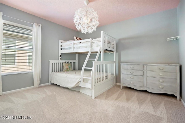 unfurnished bedroom featuring light carpet, a textured ceiling, and a notable chandelier