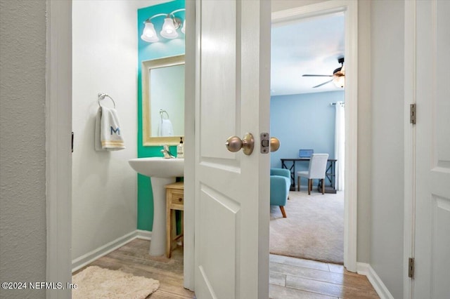 bathroom with ceiling fan and hardwood / wood-style flooring