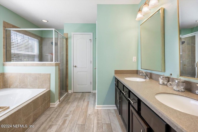 bathroom with hardwood / wood-style floors, vanity, and separate shower and tub