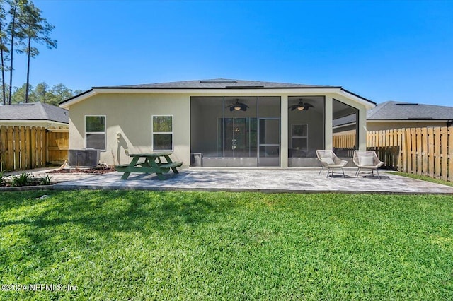 back of house featuring a sunroom, ceiling fan, a patio, and a lawn