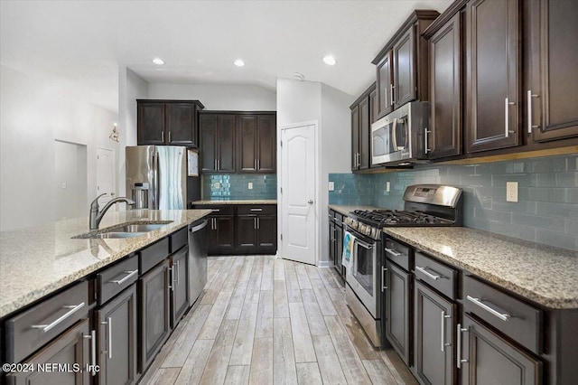 kitchen with sink, tasteful backsplash, light hardwood / wood-style floors, dark brown cabinetry, and stainless steel appliances