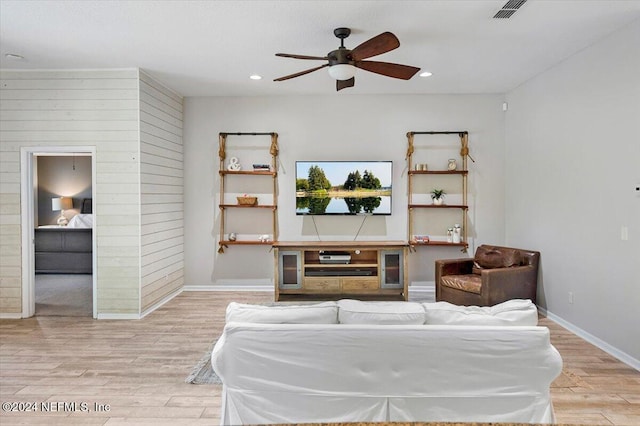 living room with ceiling fan and light hardwood / wood-style flooring